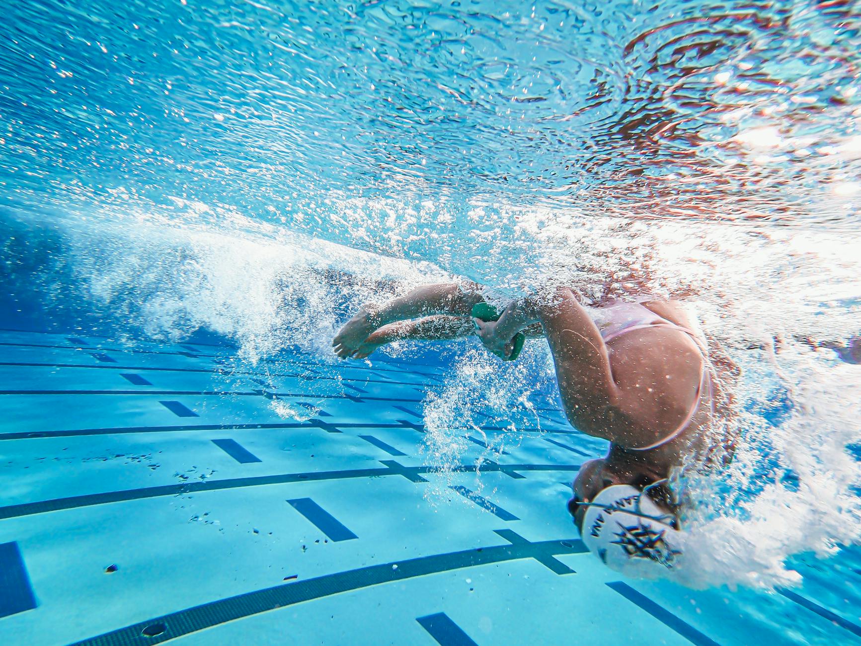 Underwater photo of a woman swimmer performing a flip turn in a swimming pool.