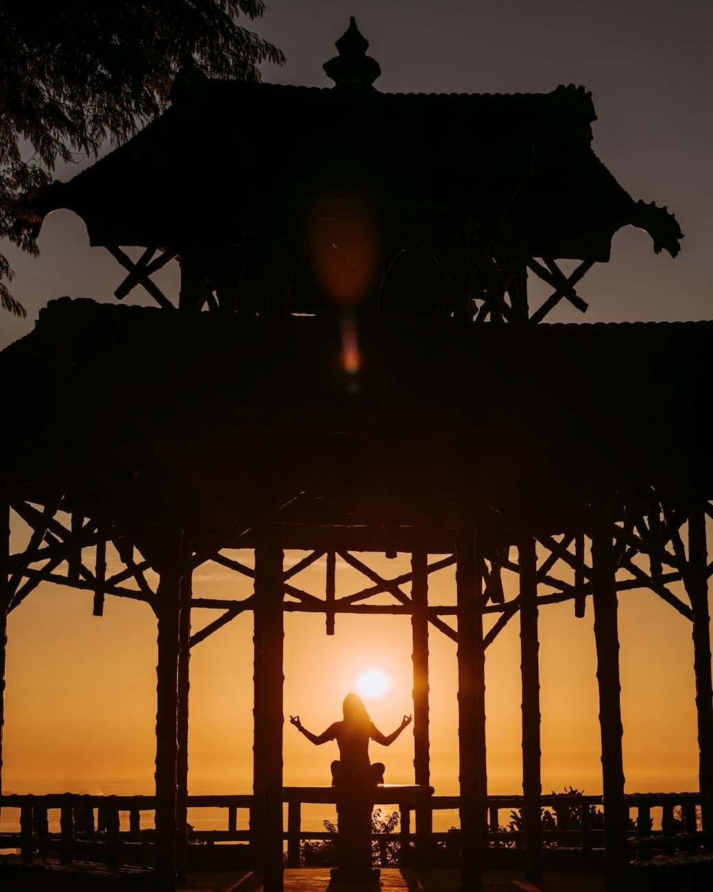 Serene silhouette of a person meditating in a gazebo at sunset, Rio de Janeiro.