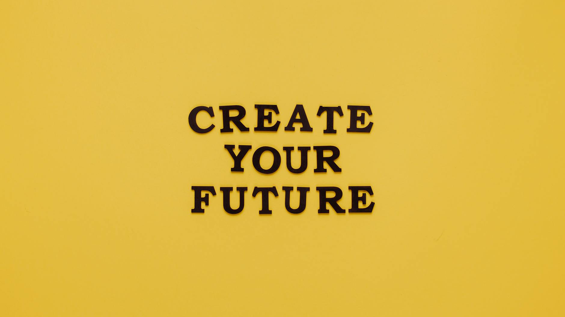 Bold text 'CREATE YOUR FUTURE' on minimalist yellow background. Inspiring design.