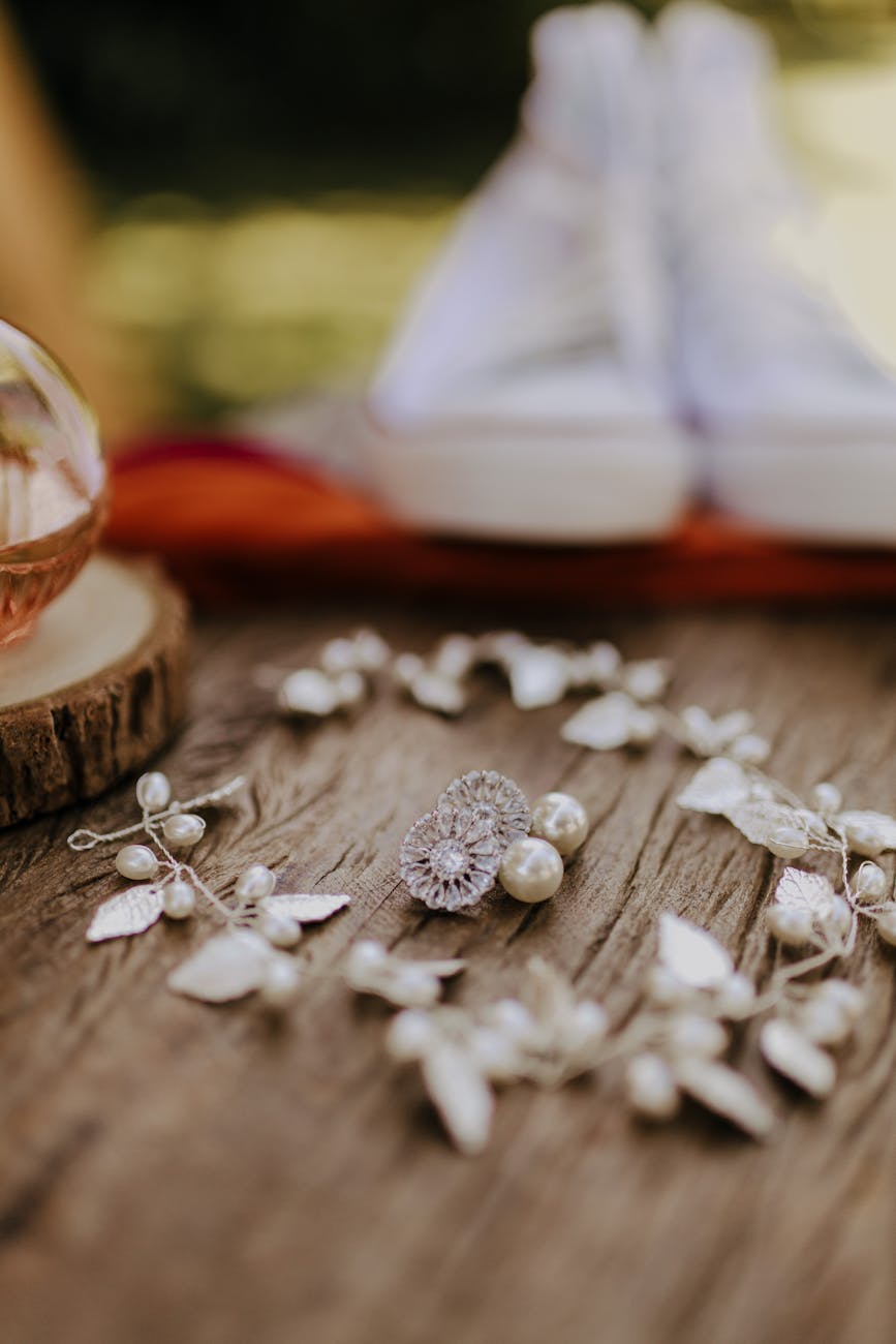 Elegant wedding jewelry arrangement with blurred sneakers in a rustic setting.