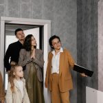 A family with children tours a new house guided by a realtor. Ideal for real estate themes.