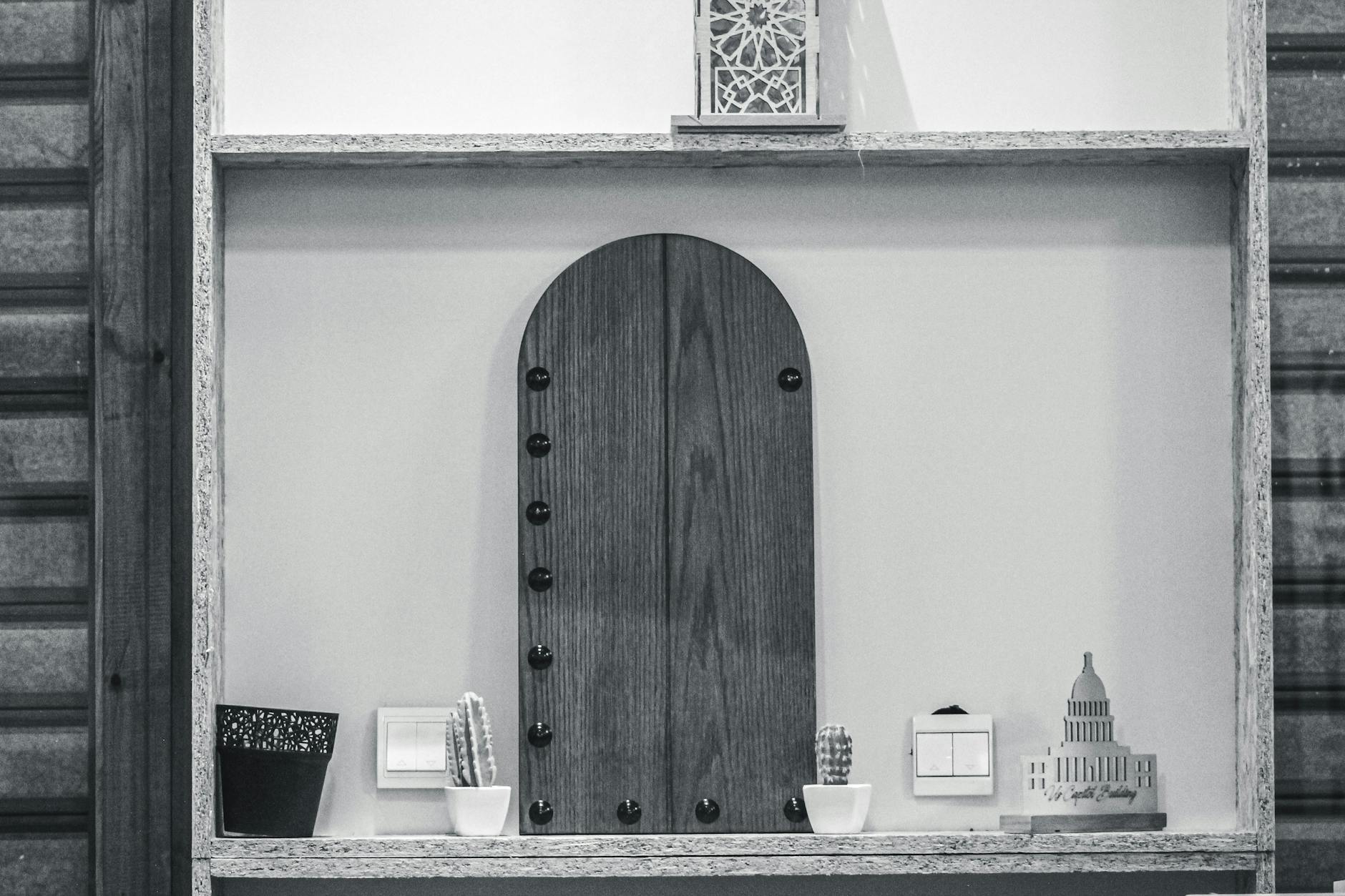 Minimalist wooden shelf with small cacti and decor pieces, emphasizing simplicity and style.