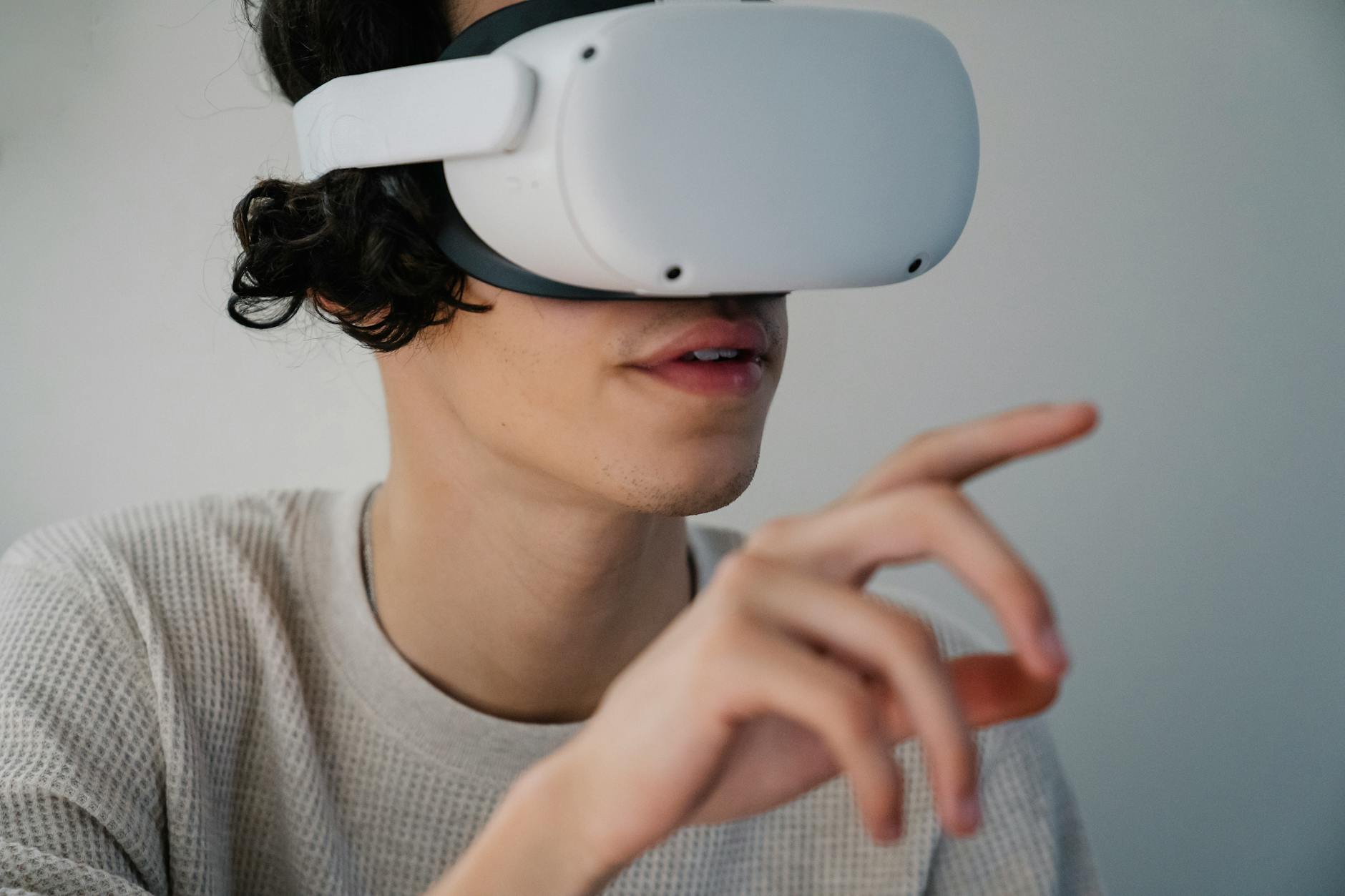 Close-up of a young man using a VR headset to explore virtual reality indoors.