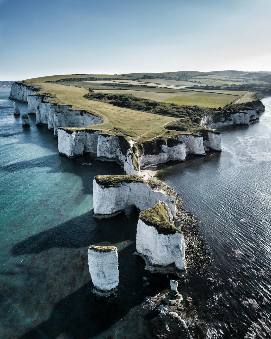 Breathtaking aerial view of England's scenic Old Harry Rocks on a sunny day.