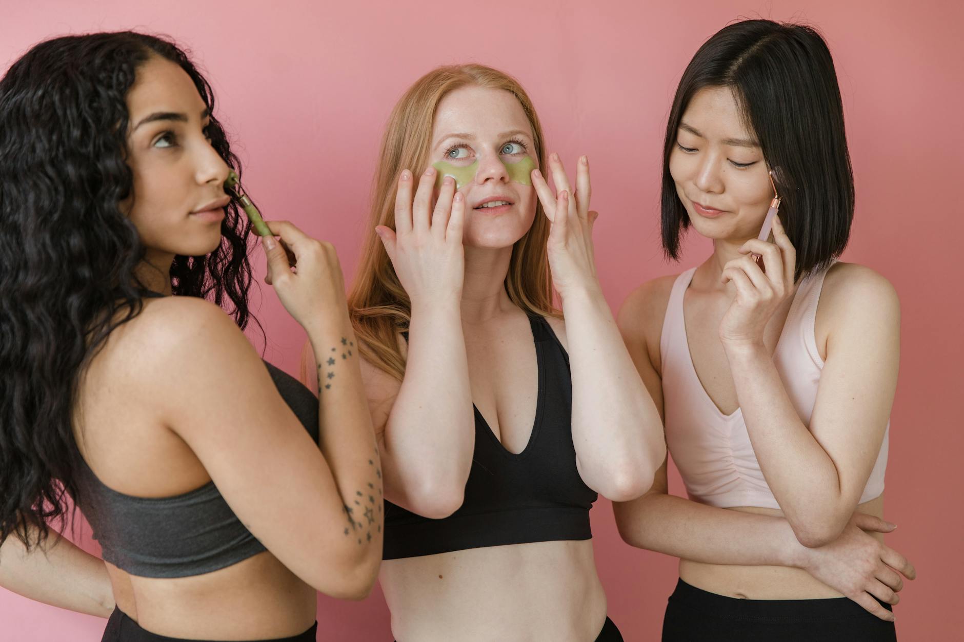 Three women of different backgrounds applying skincare products, embodying beauty and diversity.