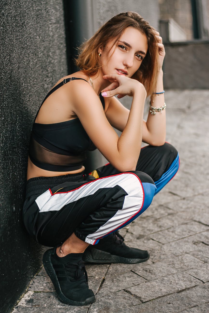 Fashionable young woman in sporty attire posing confidently in urban São Paulo setting.