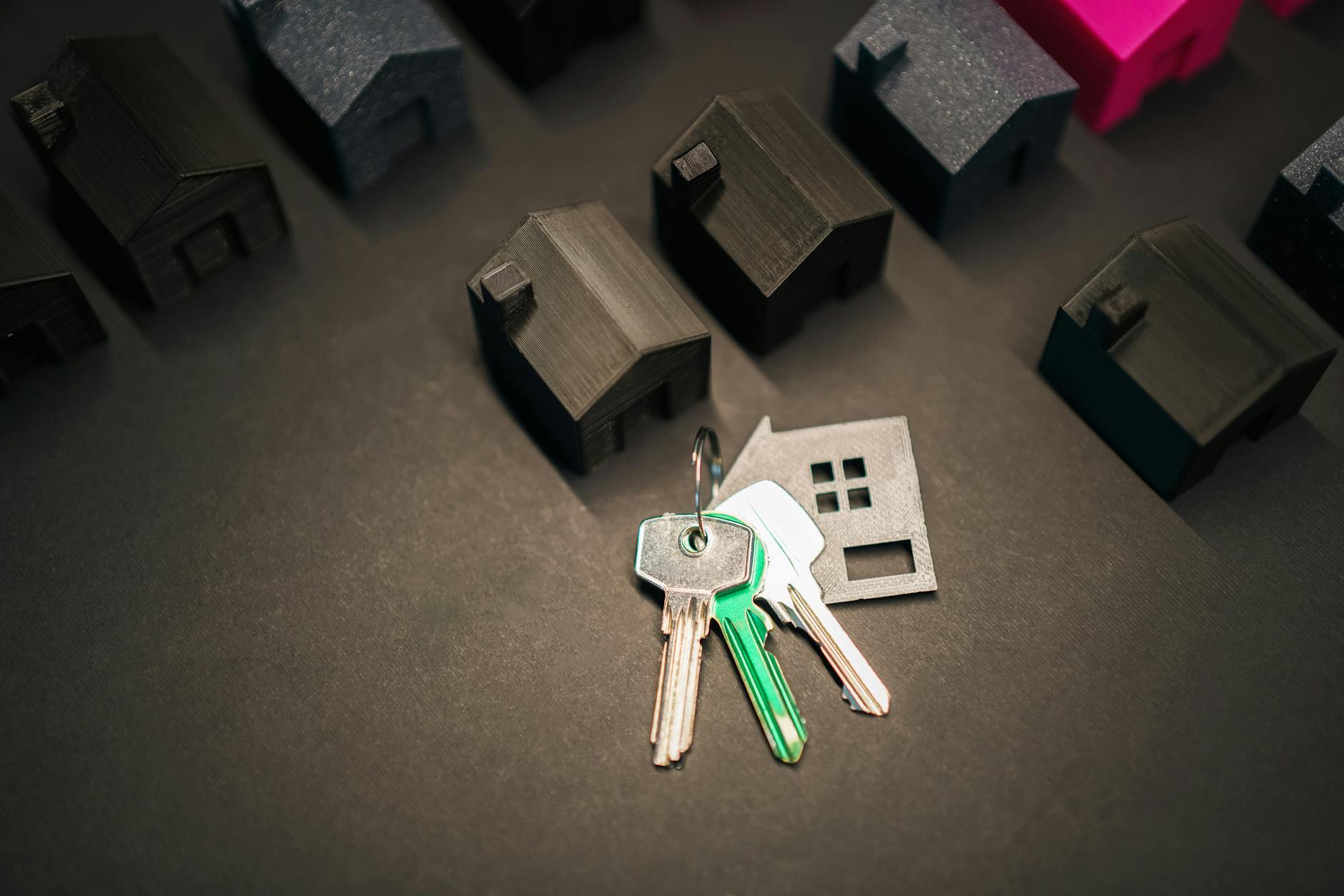 Miniature house models and keys symbolize real estate investment and housing market.