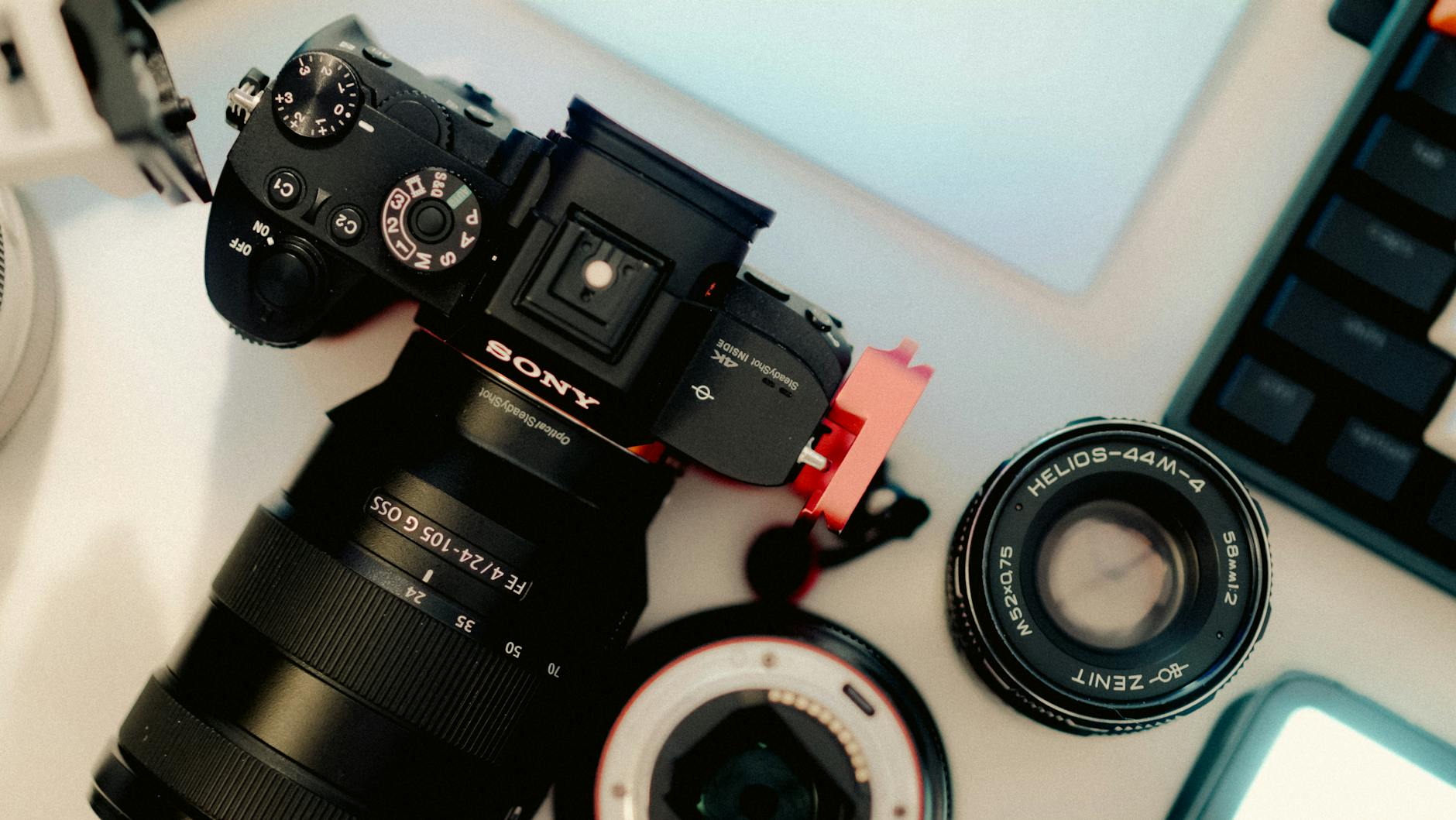 A top view of a camera and lenses on a desk, showcasing photography equipment.