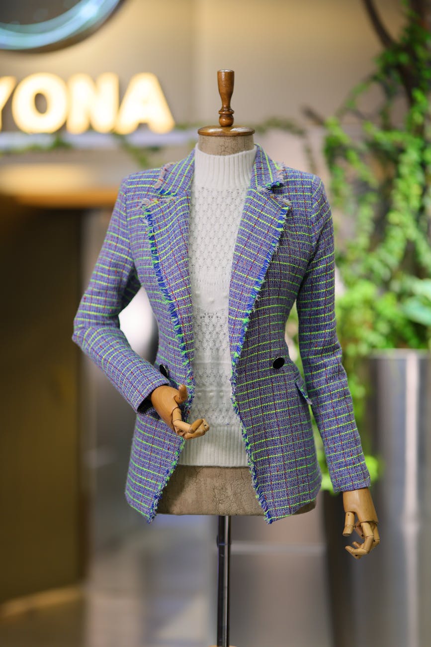 Chic tweed blazer showcased on a mannequin in a modern fashion store setting.