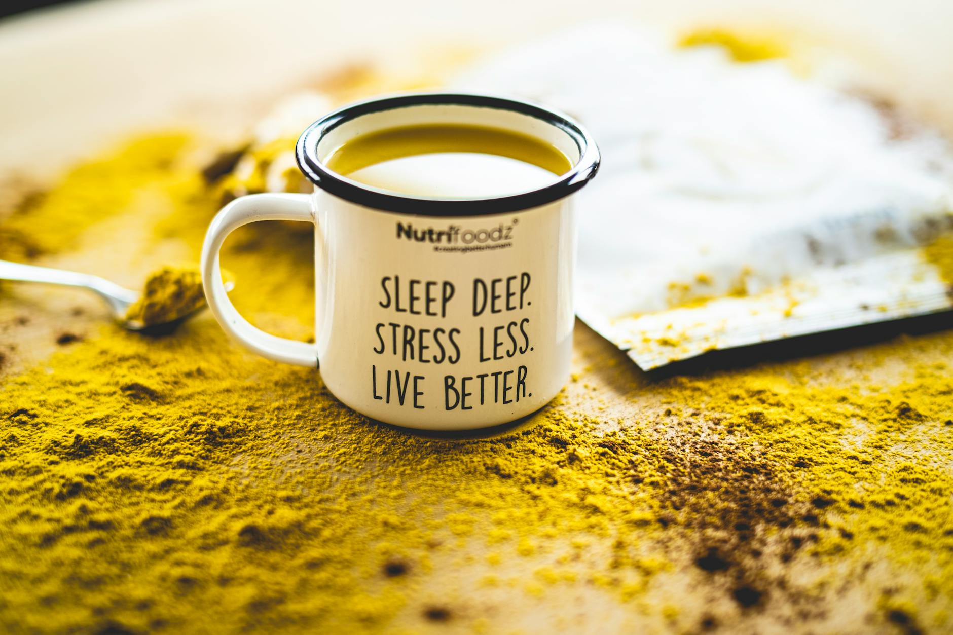 A motivational mug sits on vibrant turmeric powder, promoting relaxation and wellness.